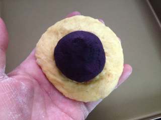  全麦紫薯南瓜面包,把松弛好的小面团擀成圆片包上紫薯馅，捏紧收口。