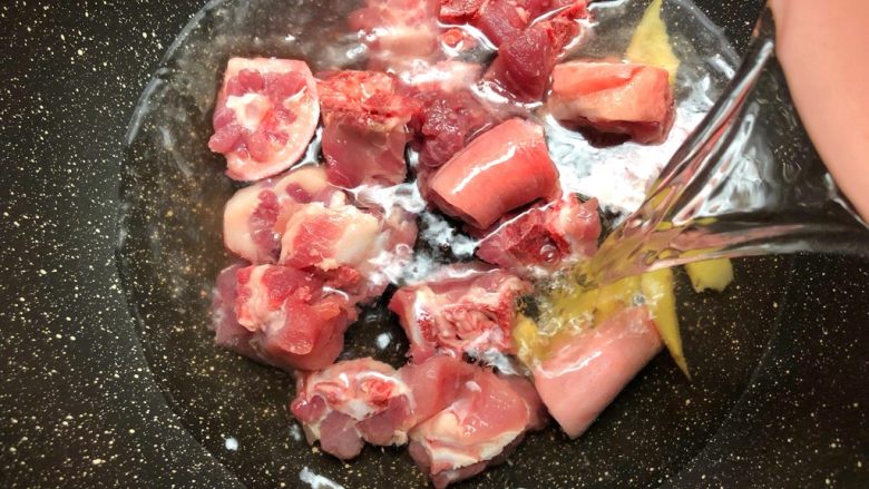 猪尾骨炖石橄榄,猪尾骨放入锅里，放入姜片，倒入和食材齐平的水，大火把水烧开。