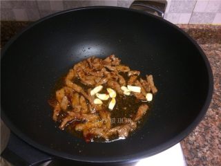 十味 芦笋炒牛肉,放入大蒜片翻炒片刻。