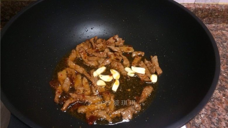 十味 芦笋炒牛肉,放入大蒜片翻炒片刻。