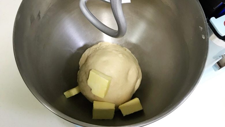 牛奶炼乳蔓越莓软欧,揉至面团光滑，呈扩展阶段，往搅拌桶内加入黄油。