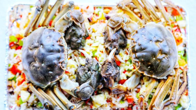 美食丨膏蟹焗饭 鲜香弥漫 垂涎何止三尺！,把处理好的大闸蟹放在炒饭上，肚子那边朝下。