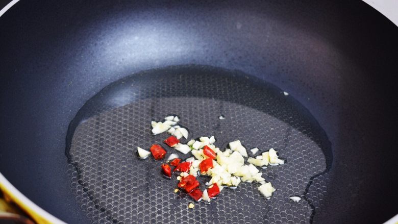 孜然杏鲍菇,锅中倒入适量的食用油烧热，放入蒜末和干红辣椒爆香