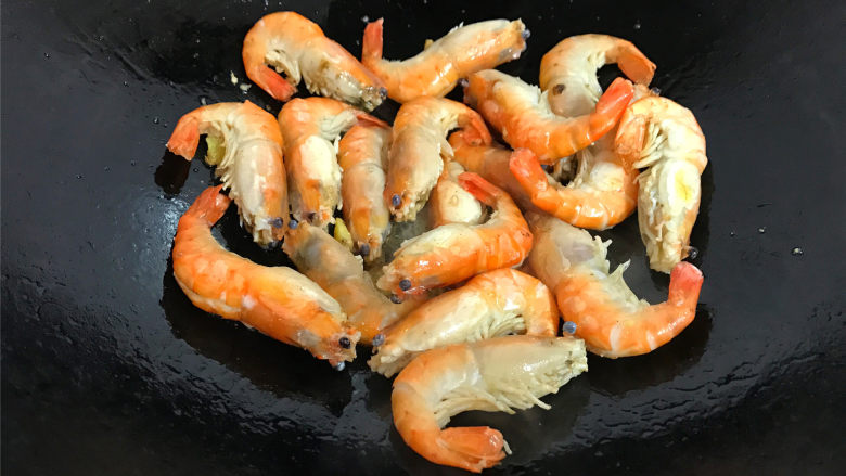 家常红烧大虾,把清洗干净的大虾沥干水份，放入锅中，爆至两面都呈金黄色。