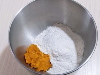 奶香果干南瓜发糕,将做好的南瓜泥与面粉放入器具中！
