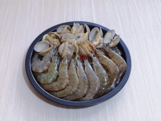 15分钟get惊艳大餐～烤海鲜,将煮开口的蛤蜊摆放在上面，腌制好的虾摆放在下面！