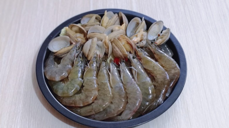 15分钟get惊艳大餐～烤海鲜,将煮开口的蛤蜊摆放在上面，腌制好的虾摆放在下面！
