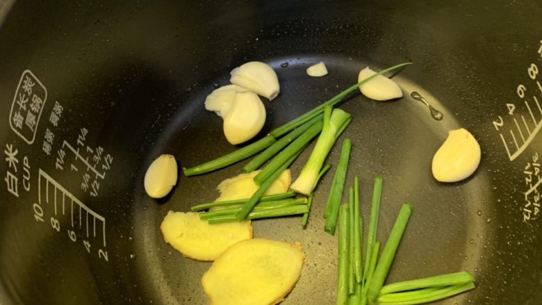 蜜汁烤鸡,把葱，姜，蒜，铺上去，然后放入鸡，按下煮饭键