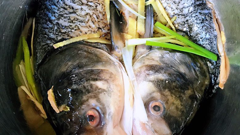 剁椒鱼头,鱼头各种按摩使调料均匀涂在鱼头上放入姜葱煨制30分钟入味