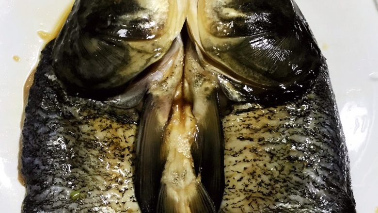 剁椒鱼头,煨制入味的鱼头摆入盘中不过一定要先把葱姜丝压在鱼头下面这样蒸出来的鱼头味道更加浓郁