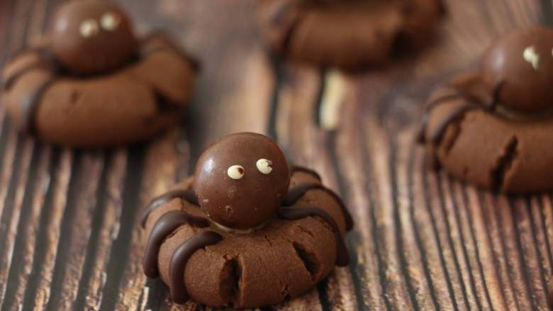 万圣节蜘蛛饼干,用巧克力装饰蜘蛛的腿和眼睛。