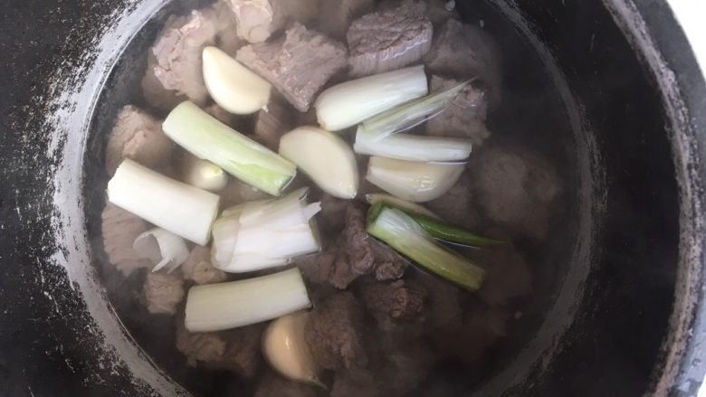 牛肉炖土豆,将去掉血水的牛肉连汤汁一起倒入高压锅内，加入葱段跟蒜，高压锅压软