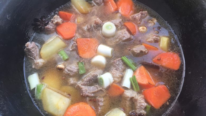 牛肉炖土豆,加入牛肉跟新鲜的葱段，盖上锅盖中小火慢慢炖