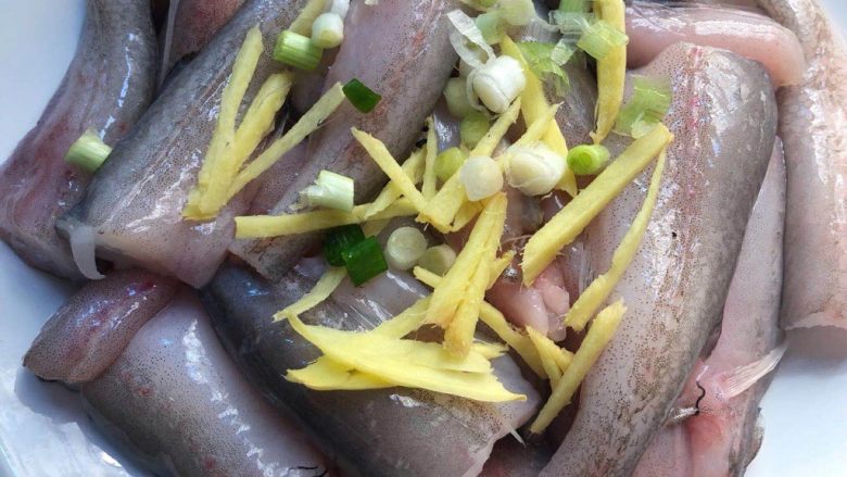 紫苏剁椒蒸龙头鱼,把姜丝和葱白放到龙头鱼上面。