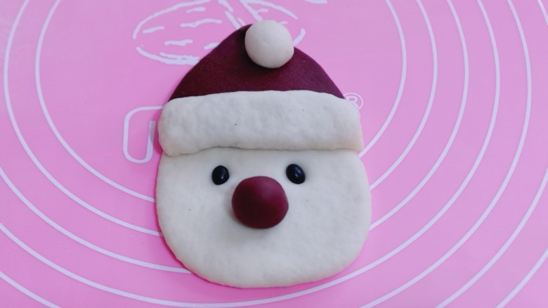 不一样的面食～圣诞老人馒头,把做好的白色小圆球放在帽子顶部、取一点红色面团做一个小圆球装饰圣诞老人的鼻子、两颗<a style='color:red;display:inline-block;' href='/shicai/ 452'>黑豆</a>做眼睛！如图