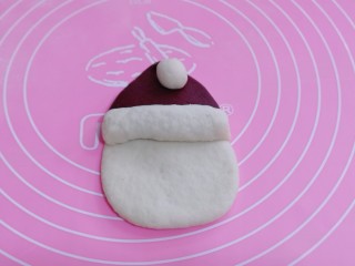 不一样的面食～圣诞老人馒头,把搓好的长条放在帽子和额头的中间做帽沿，用刀把多余的面团切掉。