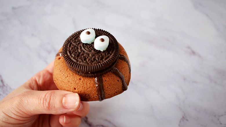万圣节甜甜圈蜘蛛蛋糕,把奥利奥饼干沾住，再用黑色巧克力笔画出蜘蛛脚，晾干即可