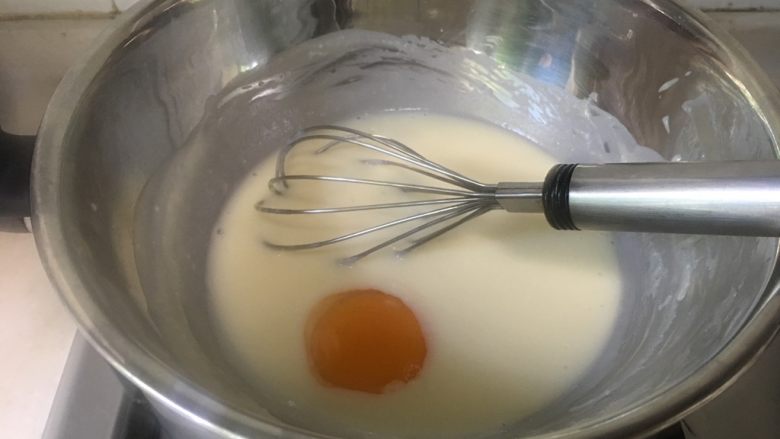 酸奶冻芝士蛋糕,加入蛋黄继续搅拌均匀。