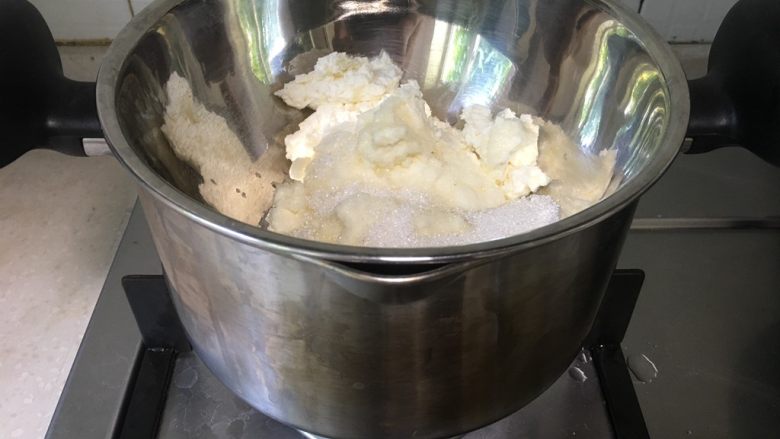 酸奶冻芝士蛋糕,奶酪和糖隔水融化，用手抽快速搅拌均匀，搅拌成糊状，细腻柔滑，无颗粒。