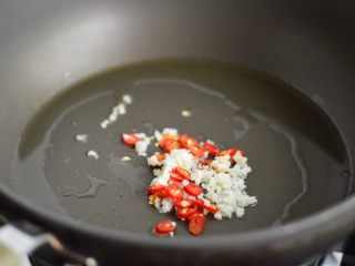 凉拌秋葵花束,锅里倒入少许油，爆香蒜蓉和小米辣