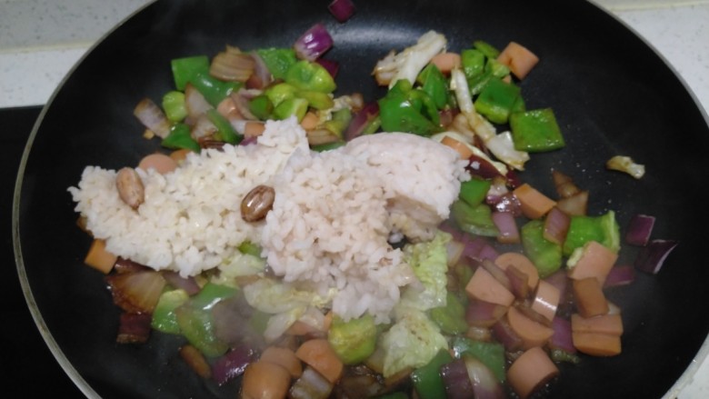 菜椒火腿炒米,翻炒均匀，倒入大米。