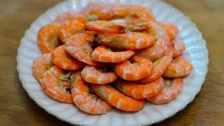 清蒸姜葱虾,夹去葱姜丝，摆入干净的盘中
