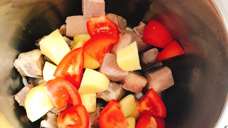 西红柿土豆炖牛腩,将牛腩粒、土豆，西红柿全部装入高压锅。