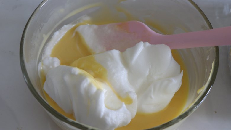 如棉花般口感的戚风蛋糕（烫面+水浴法）,取一部分蛋白和蛋黄糊混合，手法是翻拌的手法。
