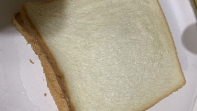 微波炉鸡蛋火腿三明治,盖上另一块面包放入微波炉，最高温叮3分钟。出锅后切边，再对半切开就可以吃了