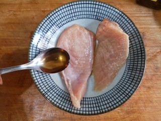 日式咖喱鸡排饭,将处理好的鸡胸肉放入碗中，加适量的盐和料酒抓拌均匀，腌制15分钟。