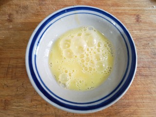 日式咖喱鸡排饭,鸡蛋磕入碗中打散成蛋液。