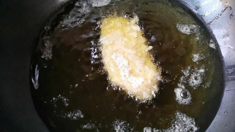 日式咖喱鸡排饭,锅中倒入宽油（炸东西油要多一些），开火将油温加热至5成热时下入裹好面包糠的鸡胸肉。