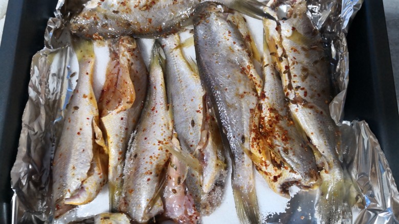 盐焗小黄鱼,将鱼逐条整齐地铺在盐上，只平铺一层，不要垒起来。
