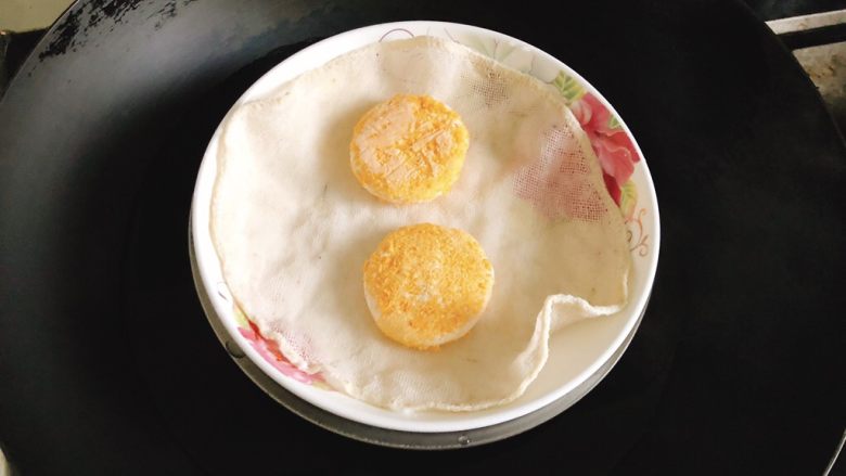 咸味南瓜饼,想给小孩子吃又怕上火，可蒸着吃。在碗里放一块湿的蒸布，将南瓜饼放上去隔水蒸15分钟。