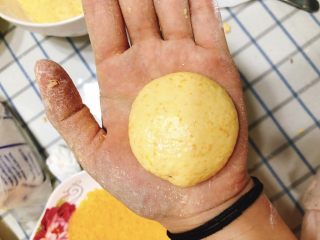 咸味南瓜饼,取一小块面团放手揉成球状，再稍用力压扁成圆形南瓜饼。