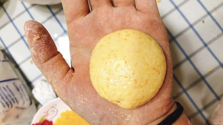 咸味南瓜饼,取一小块面团放手揉成球状，再稍用力压扁成圆形南瓜饼。