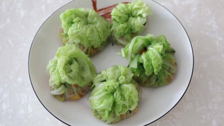 百财福袋,用韭菜将白菜包系好，放入盘中。