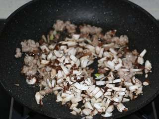 香菇糯米烧麦,翻炒至猪肉馅变白后，加入香菇丁翻炒。