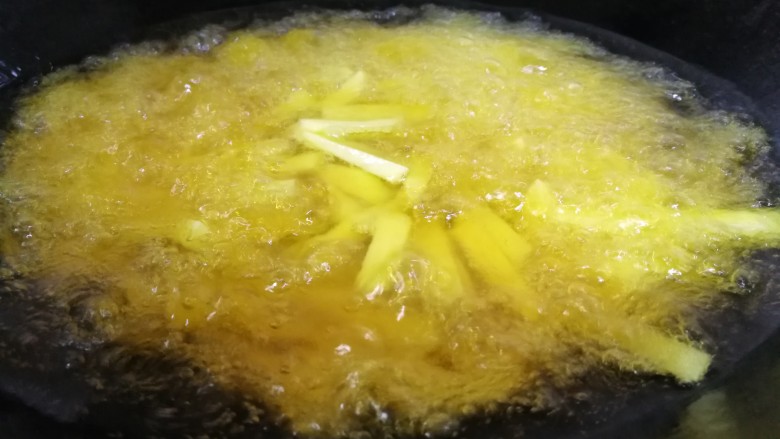家常菜#牛肉炒蒜苗土豆#,锅添油烧9分熟，放入土豆条炸。