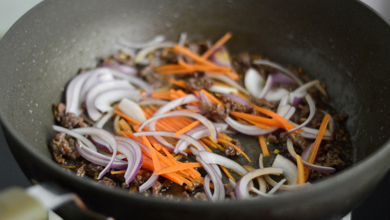 香根洋葱牛柳丝,放入洋葱和胡萝卜丝，翻炒至断生