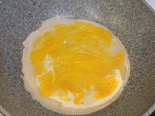 鸡蛋饼,面饼凝固定型后加入2个鸡蛋，戳散鸡蛋