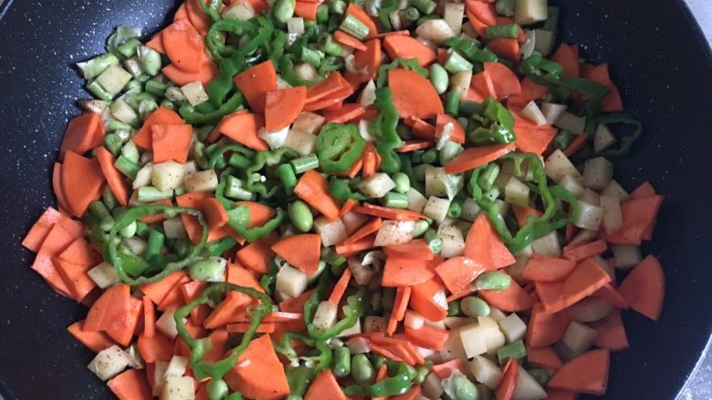扯面,油熟后，将切好的土豆、红萝卜、毛豆、豇豆、青椒倒入锅内开始炒