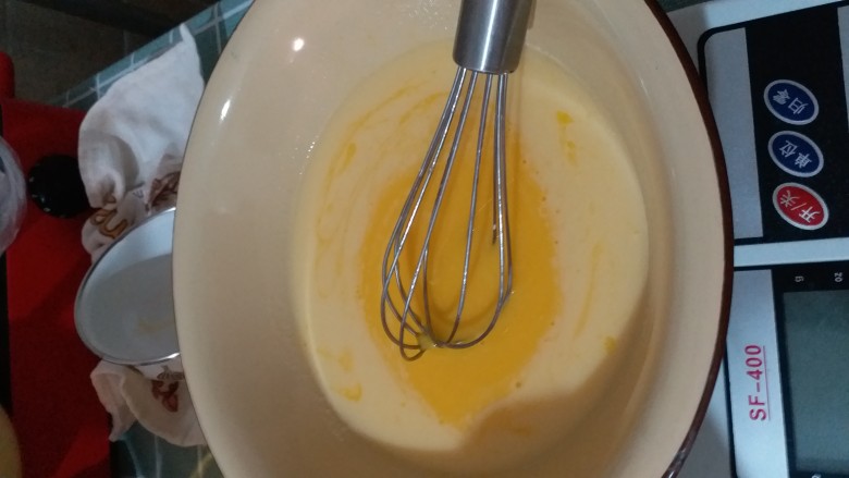 果味戚风,把这碗液体倒入装着四个蛋黄的盆里，不停搅拌，一边倒一边搅拌。