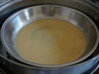 椰香千层马蹄糕,锅里的水烧开后，放上不锈钢碟子，先勺入一勺红糖粉浆，盖上锅盖，隔水蒸五分钟至凝结。