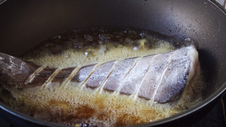 红烧鲽鱼,当油六、七成热时放入鱼，此时改中火。 煎鱼时随时微微调整火的大小，千万不要让油起烟。 
六、七成热的油温是如何判断呢，就是油面有明显的波动。 
往油锅里放鱼时，用双手分别拎住鱼头和鱼尾，贴着油面轻轻地放入。 
我使用的是不粘锅。 如果小伙伴们使用的是铁锅就要把锅烧的热热的，然后用姜在锅里涂抹一层，再继续操作。
