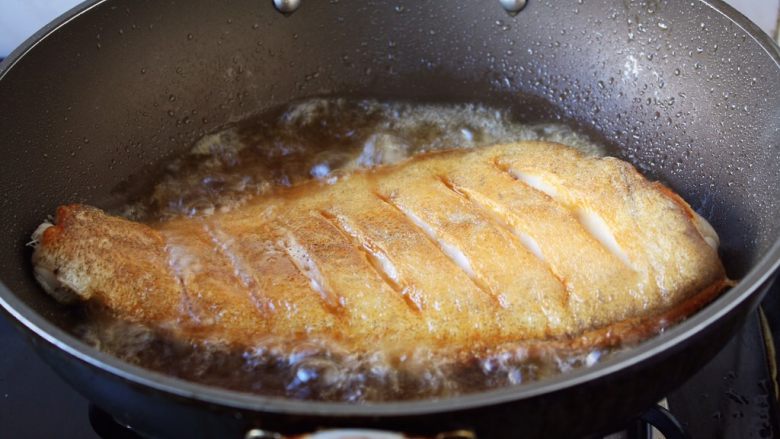 红烧鲽鱼,当鱼的一面煎至金黄色时翻过来再煎另一面，两面都煎至金黄色就OK了。 
温馨提示，当把鱼刚刚放到锅里后千万不要急于翻动，如果翻动了，肯定会粘锅的，因为油很热，鱼和铲子都是凉的，热油一下子就会“抱住”铲子和鱼，肯定会粘锅。 
那么我们什么时候才能翻动鱼呢，1，中火煎制至少2分钟后才能翻动。2，还有就是被煎鱼的那面两边会有明显的金黄色才可以翻动。3，再有就是当离火晃动锅时，鱼可随意在锅里滑动也可以翻动。建议初学者用第2种方法判断。 温馨提示，因为鱼比较大，在翻动鱼时请用两把铲子翻动。