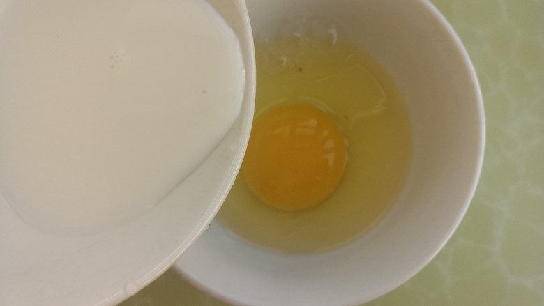 花生酱鸡蛋牛奶吐司,把鸡蛋打入碗中，然后倒入牛奶。