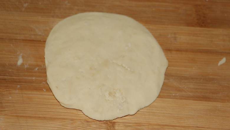 奶香紫薯饼,取一个小面团揉圆擀成面皮。