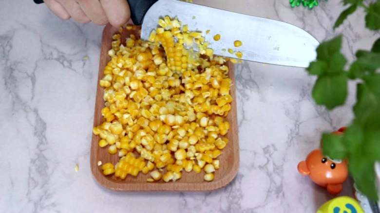 奶香玉米糊,用刀切下玉米粒
tips：这里我是用了很粗暴的方法将玉米粒剥下来，大家如果有耐心可以用手剥玉米粒