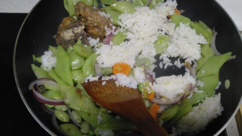 排骨扁豆炒米,倒入大米。